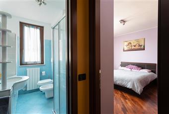 Camera da letto matrimoniale con balcone e pavimento in parquet. Lombardia MI Magnago