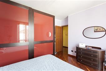Camera da letto matrimoniale con pavimento in parquet e balcone. Lombardia MI Magnago