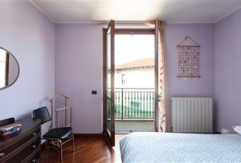 Camera da letto matrimoniale con pavimento in parquet e balcone. Lombardia MI Magnago